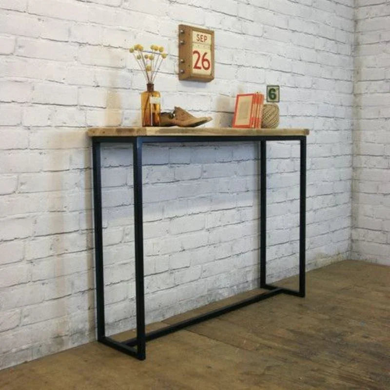 Modern industrial console table with metal frame and wooden top against white brick wall